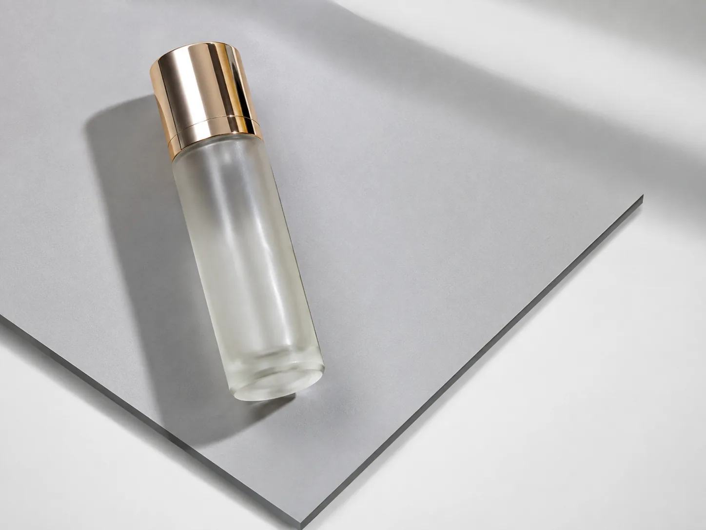 Skincare bottle photographed against a gray PVC board backdrop